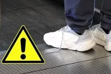 年轻情侣自动扶梯上接吻，动作幅度过大，险些重重摔下......